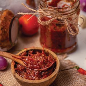 chutney in a wooden bowl with a spoon